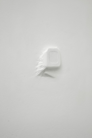 Concealed Voice, 2015                                                      
Found broken mouth piece from a telephone, tissue,
acrylic paint, plasterboard wall, 8 x 8 cm